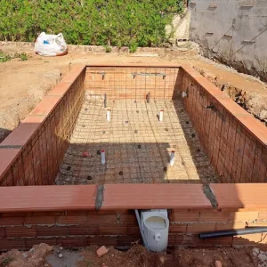 Encofrado de piscina de obra con armado y pasamuros antes del gunitado