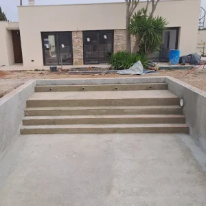 Escalera de obra con playa gunitada en piscina de obra