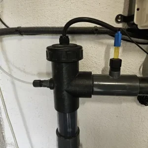 Célula de electrólisis y sonda de pH instaladas en sistema de piscina