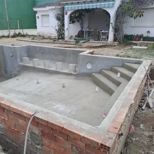 escalera y bancada en piscina de obra con gunite en Tarragona