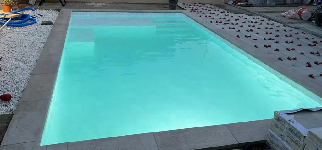piscina con lámina armada mármol blanco en Tarragona con zona de playa y agua clara