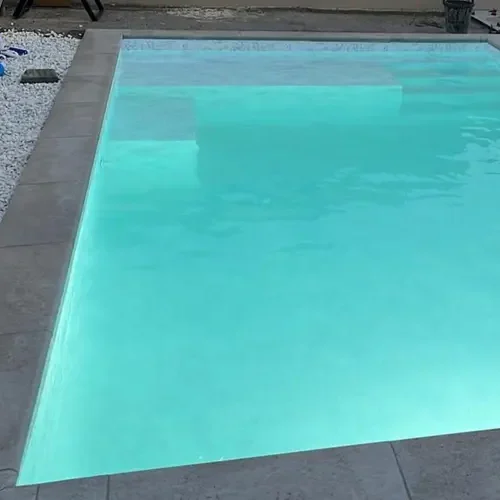 piscina con lámina armada mármol blanco en Tarragona con zona de playa y agua clara