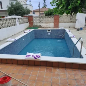 piscina de obra construida en El Francás El Vendrell con gresite azul y coronación blanca