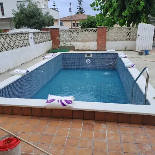 piscina de obra construida en El Francás El Vendrell con gresite azul y coronación blanca